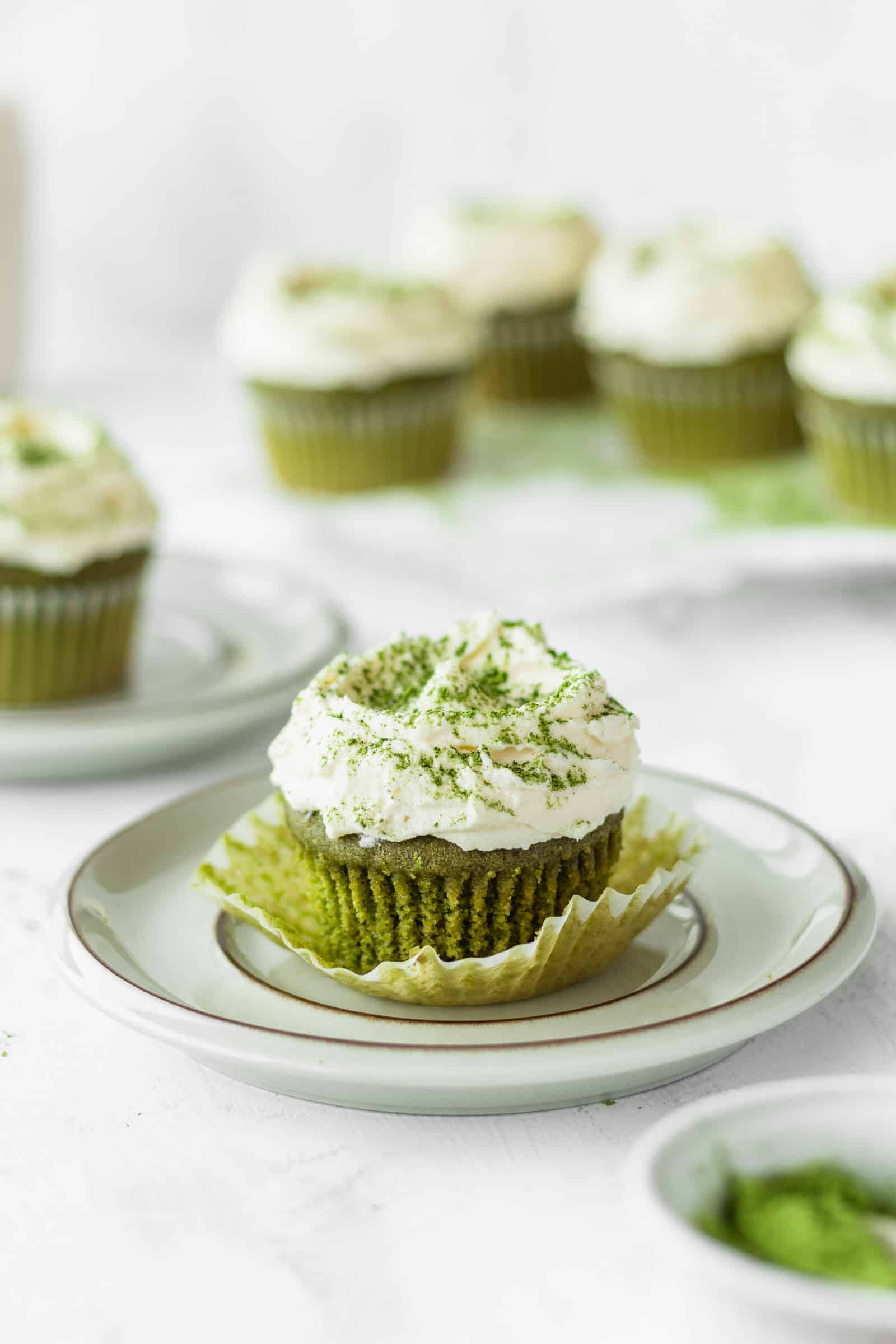 Green tea cupcake being unwrapped on a plate