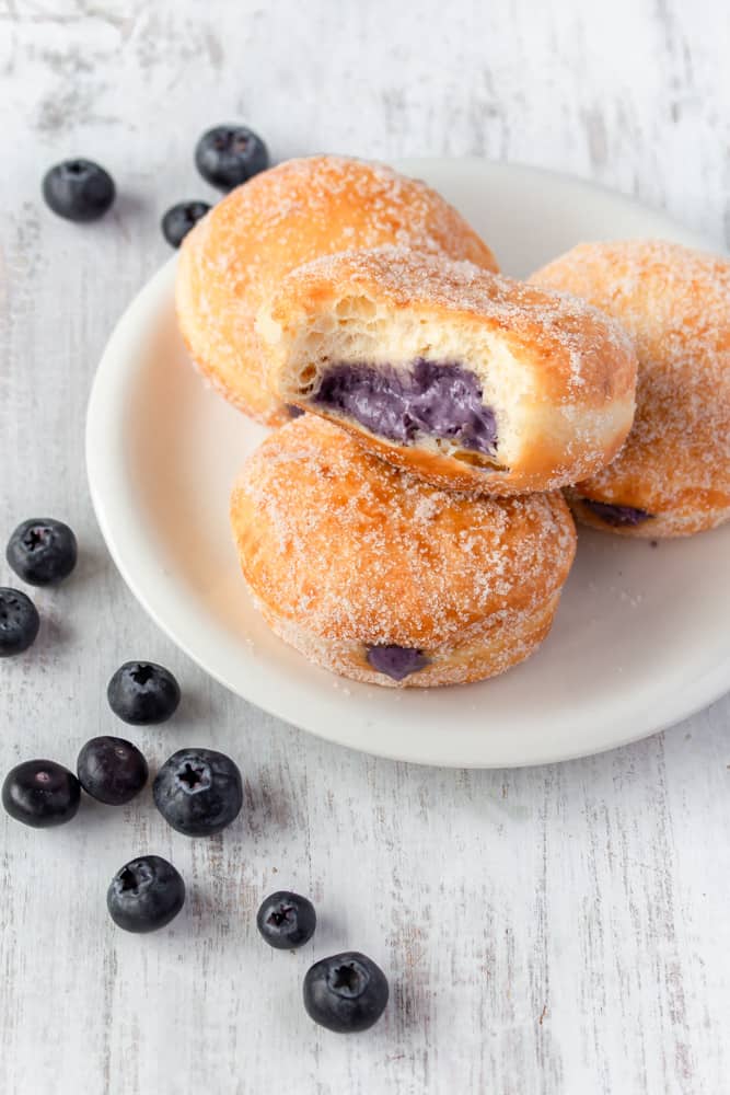 Super fluffy melt-in-your-mouth doughnuts, or donuts, that come together in a bread machine! They’re filled with a delicious blueberry cream cheese filling! #blueberry #creamcheese #doughnuts #donuts #breadmachine