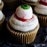 Halloween black sesame cupcakes are the perfect unique treat for an adult Halloween party! These Halloween eyeball cupcakes have a fluffy black sesame cake topped with black sesame buttercream frosting, topped with my Halloween white chocolate eyeballs! I added a spoonful of berry jam as fake blood, but I think mixing some black tahini with honey to make a spooky black goop would pair better in terms of taste. #halloween #halloweentreats #trickortreat #cupcake #cupcakes #blacksesame #kurogoma #sesame #cake #fluffy #black #spooky #creepy #dessert #halloweenparty #adult #eyeballs #whitechocolate #buttercream #frosting