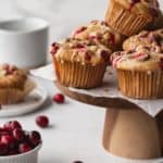 Gluten free cranberry orange muffins on a cake stand