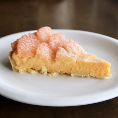 a slice of grapefruit tart on a plate.