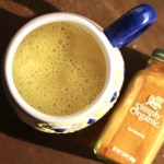 Golden Milk in a mug next to a jar of ground turmeric.