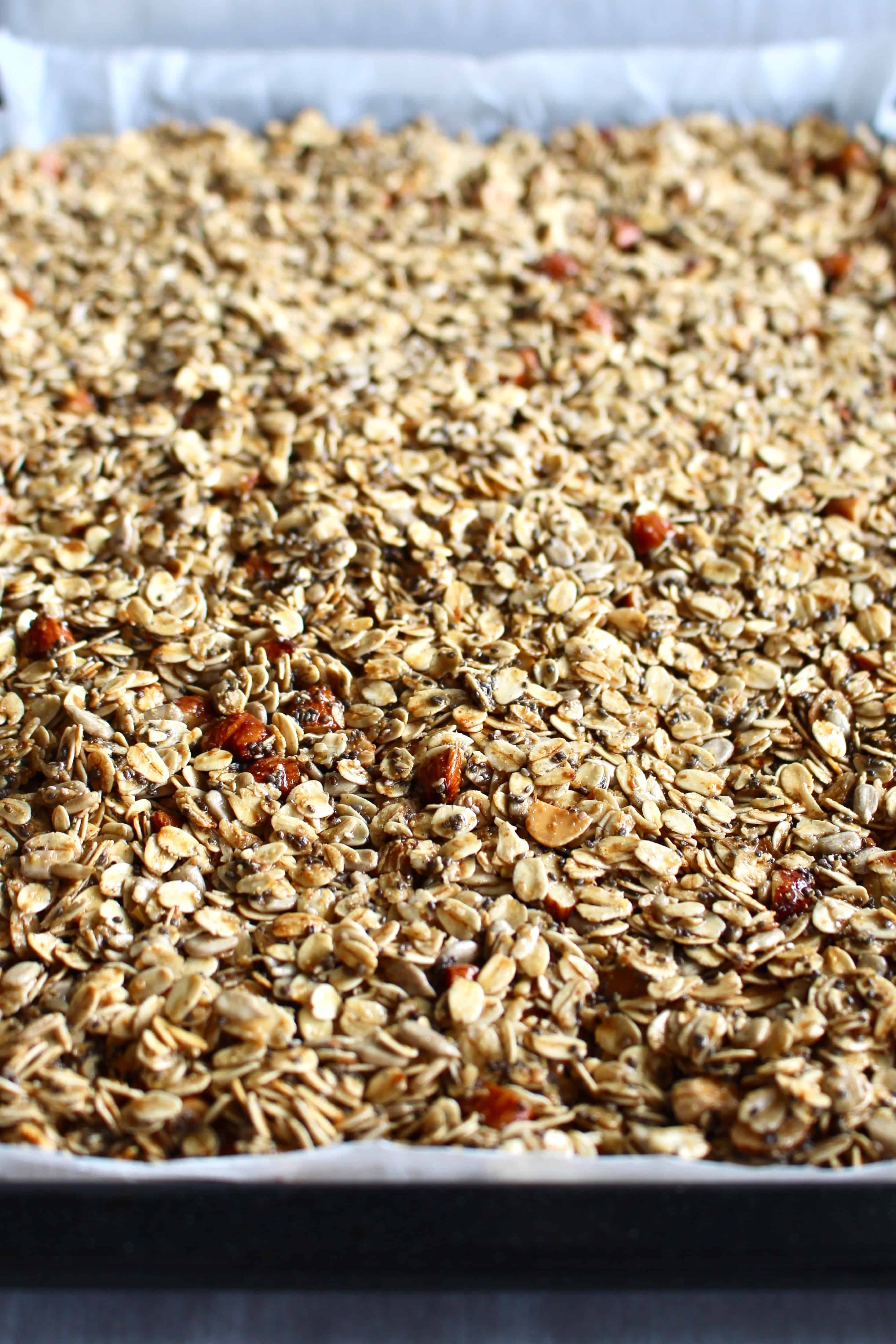 Gluten free granola spread onto a baking sheet.