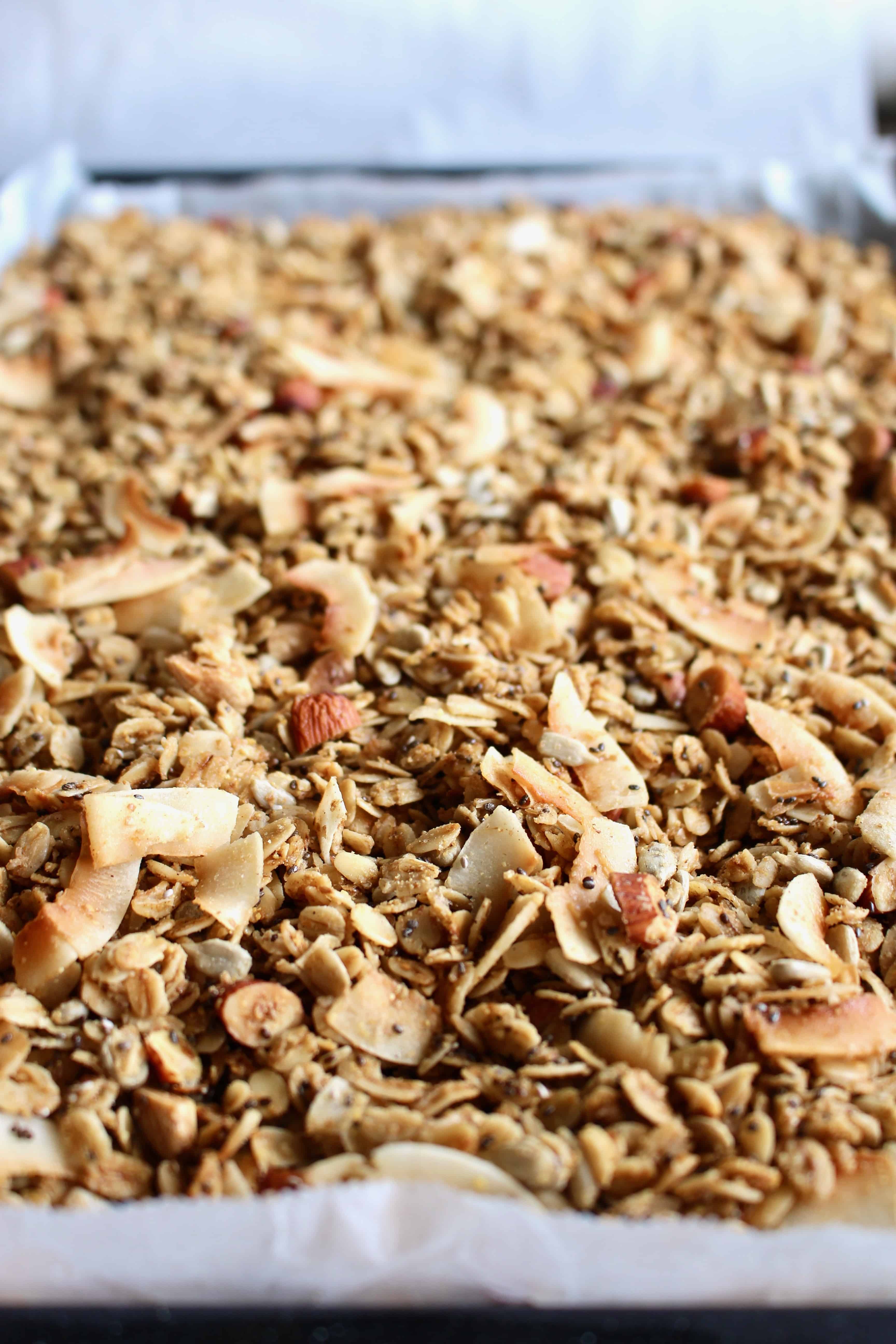 Baked gluten-free granola on a baking sheet.