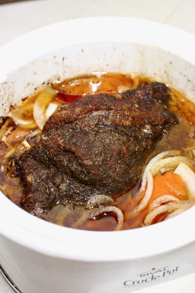 Carnitas cooking in a crock pot.