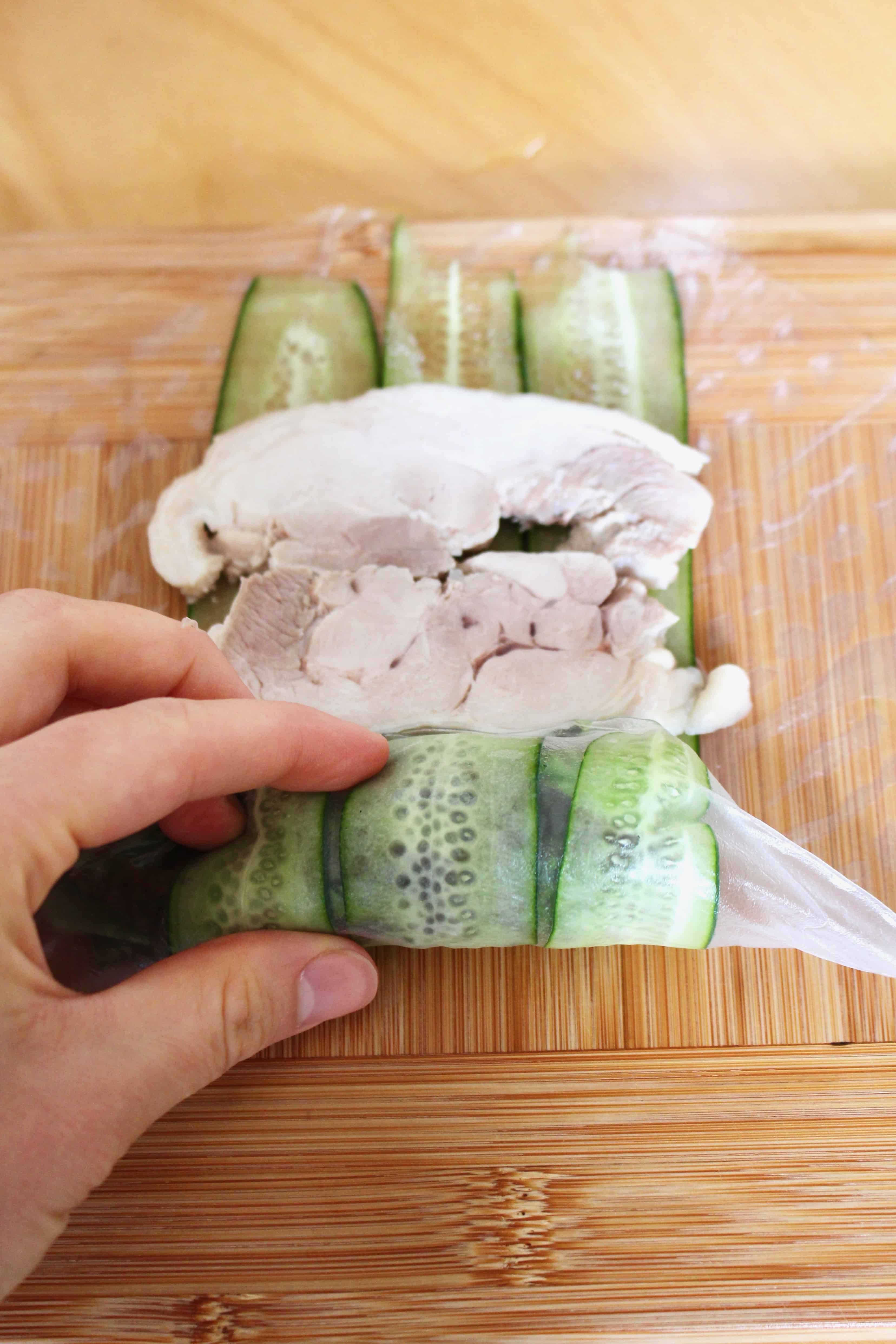 A hand rolling the summer rolls.