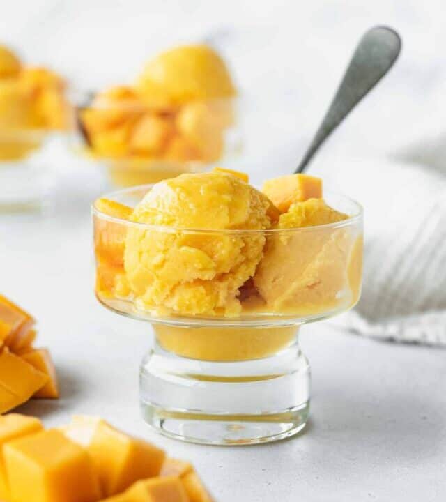 Scoops of mango lime sorbet in a glass