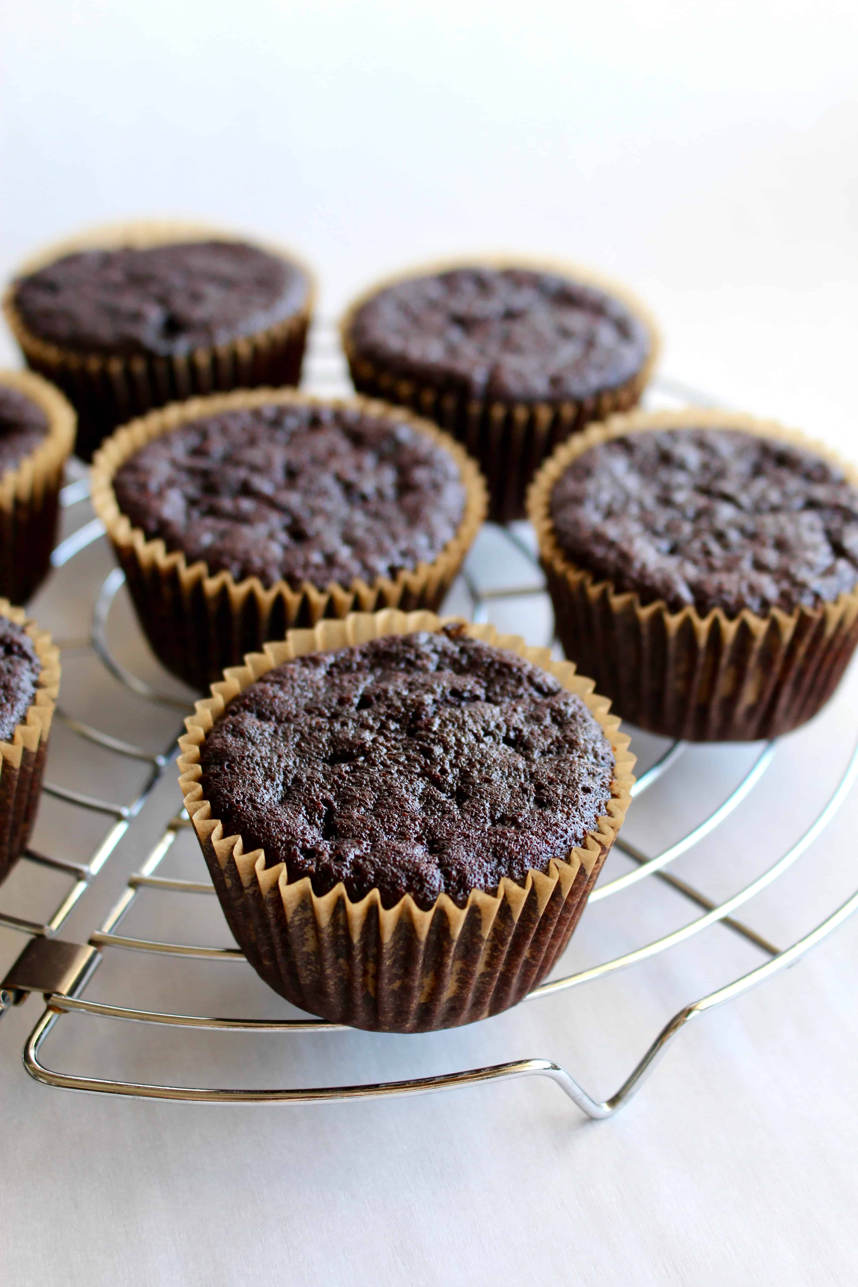 Chocolate cupcakes on a cooling rack.