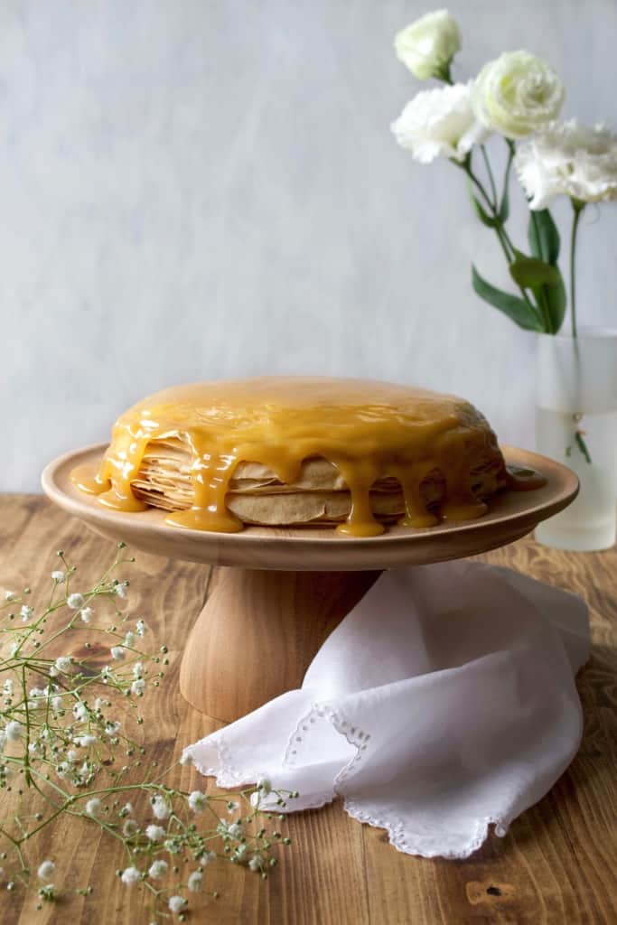 Coconut whipped cream sandwiched between layers of delicious crêpes, then topped with rich homemade dulce de leche! Whether you call it gâteau de crêpes, mille crêpe, or crepe cake, this is a beautiful and impressive dessert! #french #crepecake #crepes #pancakes #gateau #millecrepe #dulcedeleche #coconut #dairyfree #condensedmilk #caramel #cake