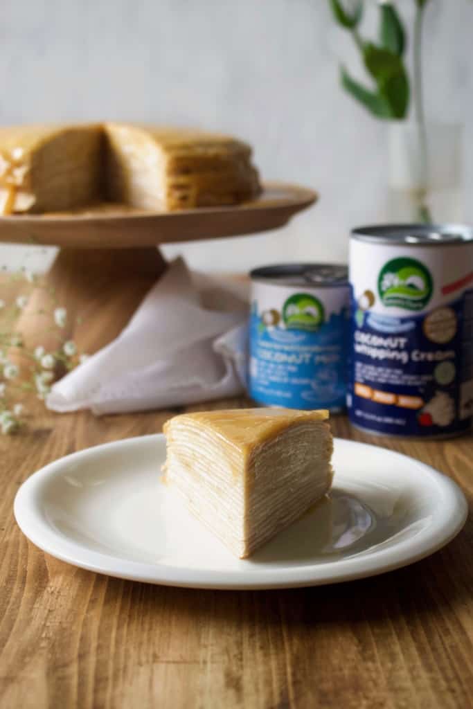 Coconut whipped cream sandwiched between layers of delicious crêpes, then topped with rich homemade dulce de leche! Whether you call it gâteau de crêpes, mille crêpe, or crepe cake, this is a beautiful and impressive dessert! #french #crepecake #crepes #pancakes #gateau #millecrepe #dulcedeleche #coconut #dairyfree #condensedmilk #caramel #cake