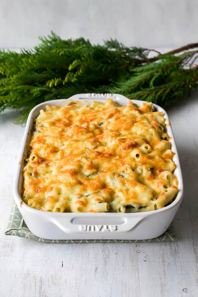 Macaroni au gratin baked in a white casserole dish.