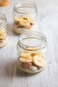 Bananas layered into a jar with cream and nilla wafers.