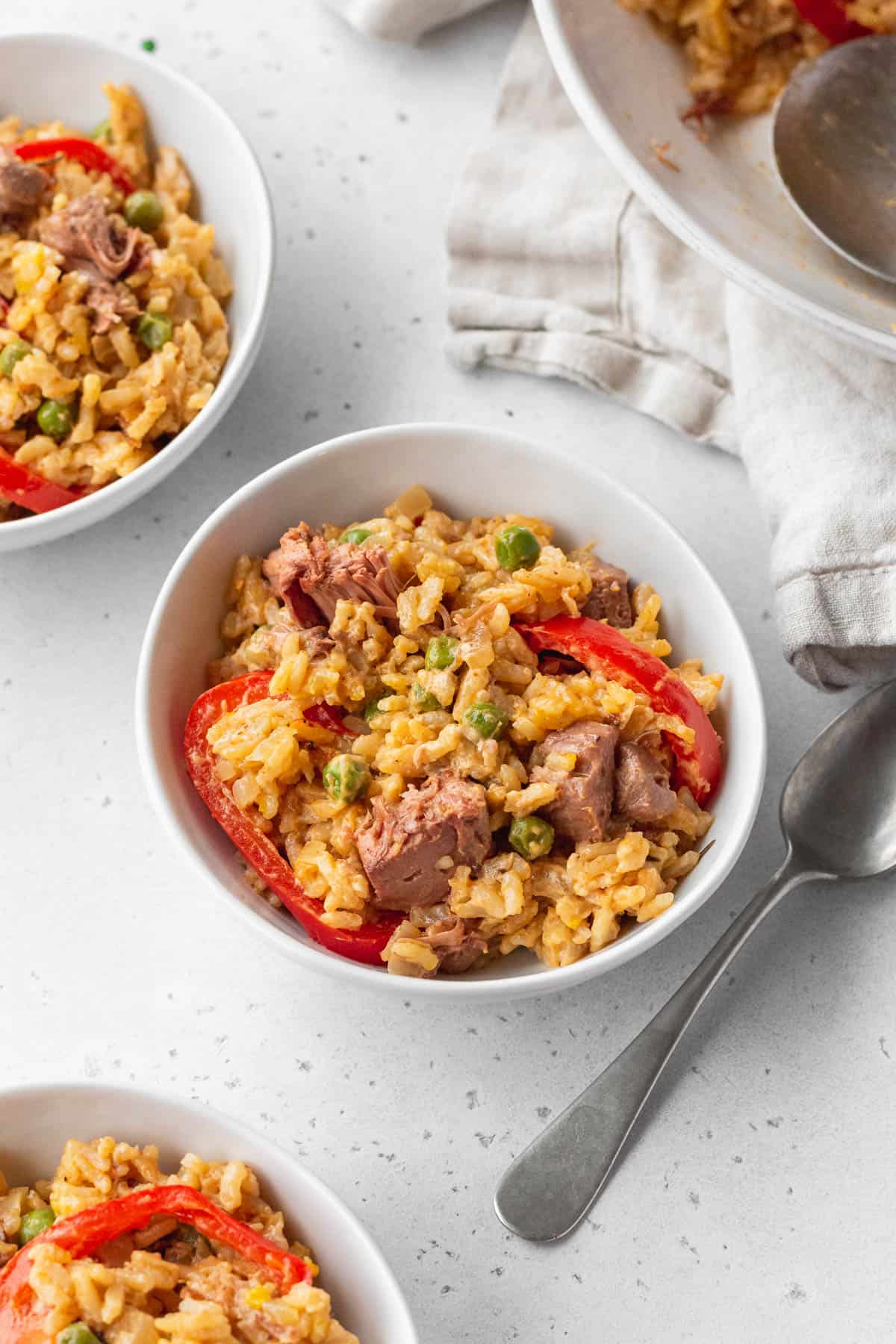 3 small bowls of Arroz a la Valenciana on a white surface.