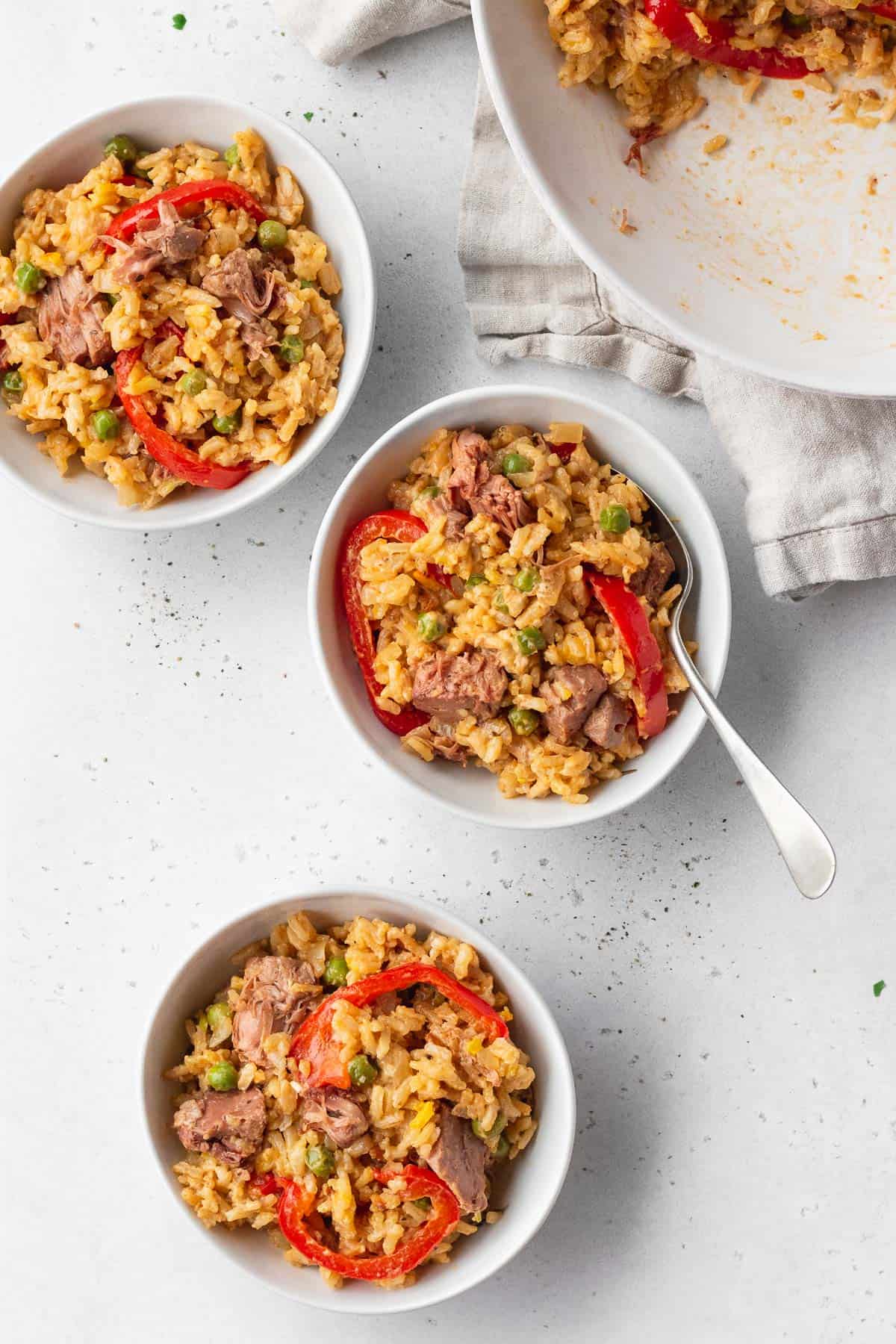 3 bowls of vegan Arroz a la Valenciana on a white table.