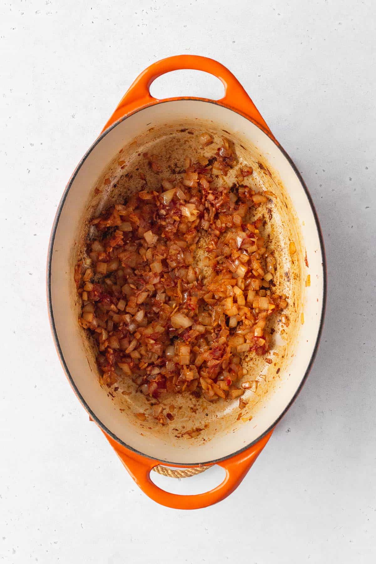 Add the spices and tomato paste to the onions.