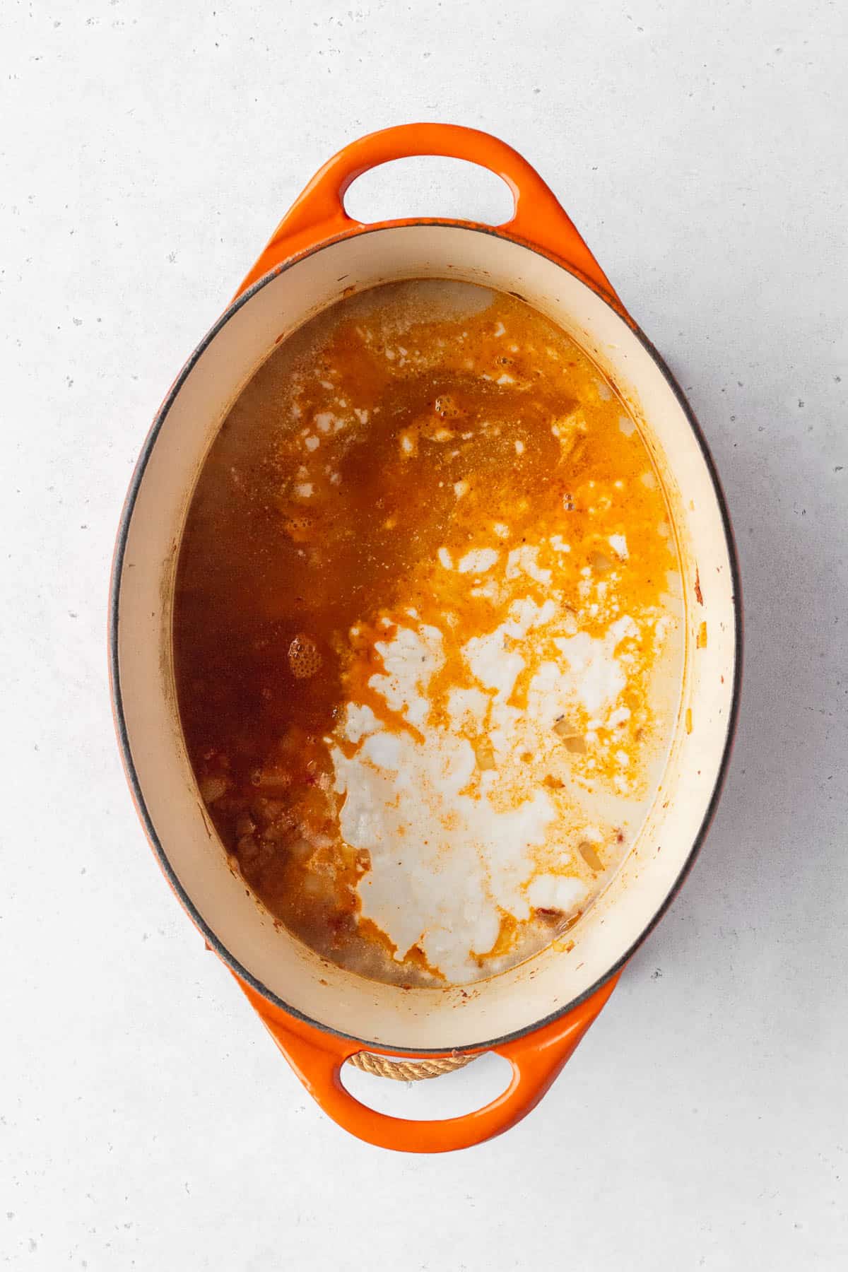 Vegetable stock and coconut milk added to the pot.