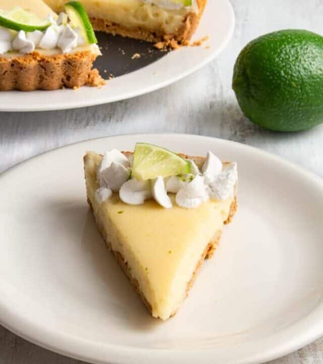 This vegan key lime pie is so creamy and tangy! With a crunchy graham cracker crust on the bottom and topped with rich coconut whipped cream, this plant based dessert won’t have you missing the traditional key lime pie! #vegandessert #vegankeylimepie #keylimepie #nobakedessert #nobakepie #plantbaseddessert