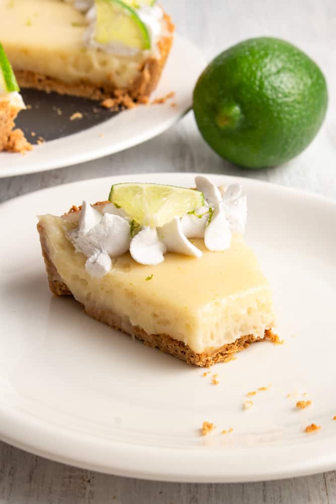 This vegan key lime pie is so creamy and tangy! With a crunchy graham cracker crust on the bottom and topped with rich coconut whipped cream, this plant based dessert won’t have you missing the traditional key lime pie! #vegandessert #vegankeylimepie #keylimepie #nobakedessert #nobakepie #plantbaseddessert