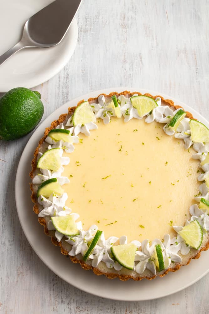 This vegan key lime pie is so creamy and tangy! With a crunchy graham cracker crust on the bottom and topped with rich coconut whipped cream, this plant based dessert won’t have you missing the traditional key lime pie! #vegandessert #vegankeylimepie #keylimepie #nobakedessert #nobakepie #plantbaseddessert