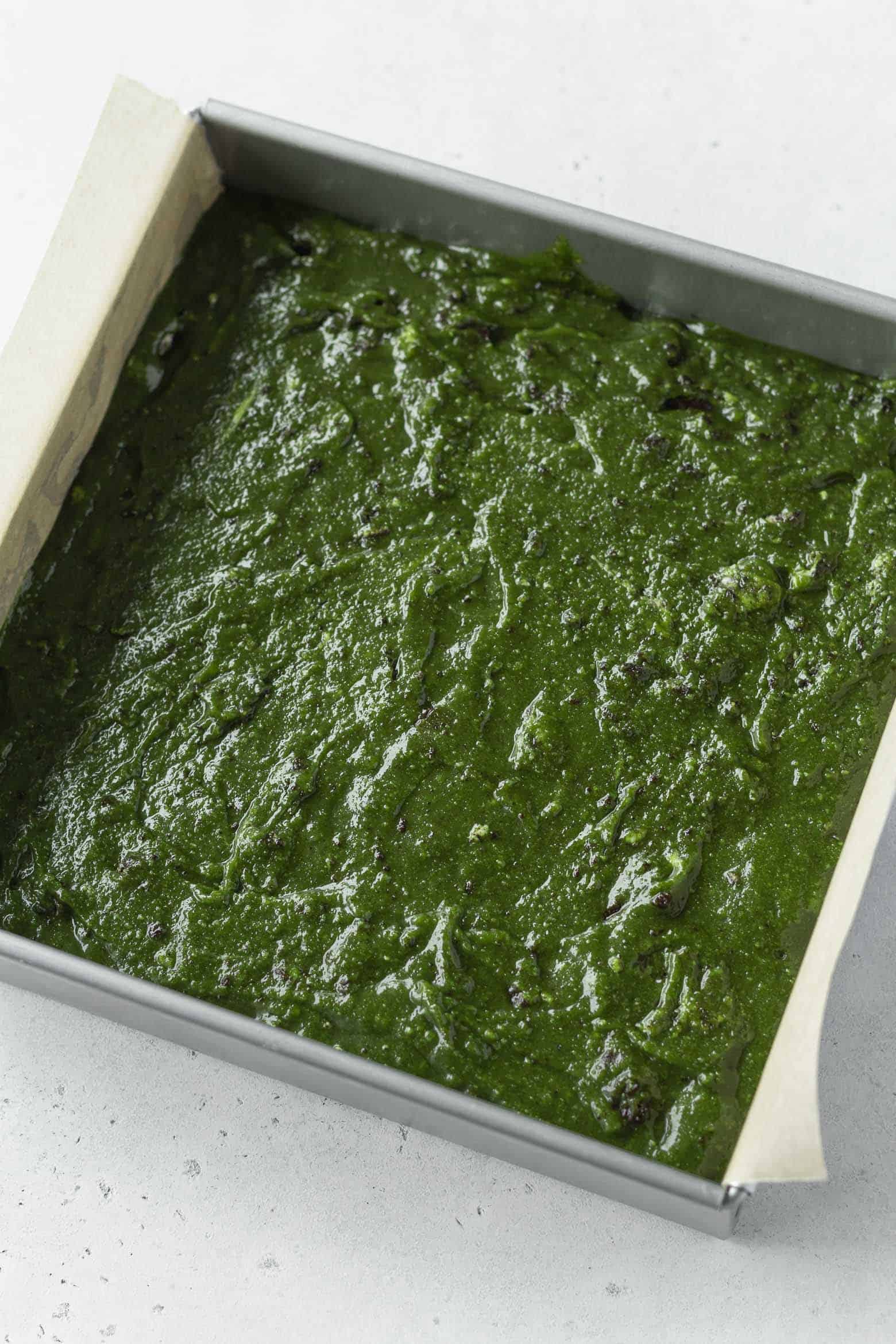 Matcha blondie batter in a square pan
