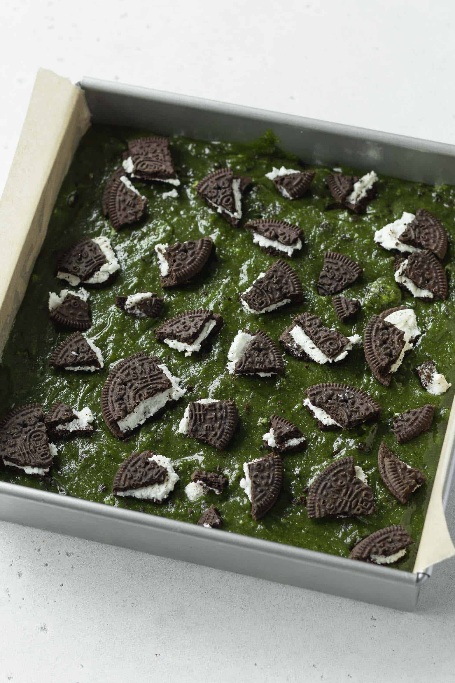 Crushed oreos on green blondie batter