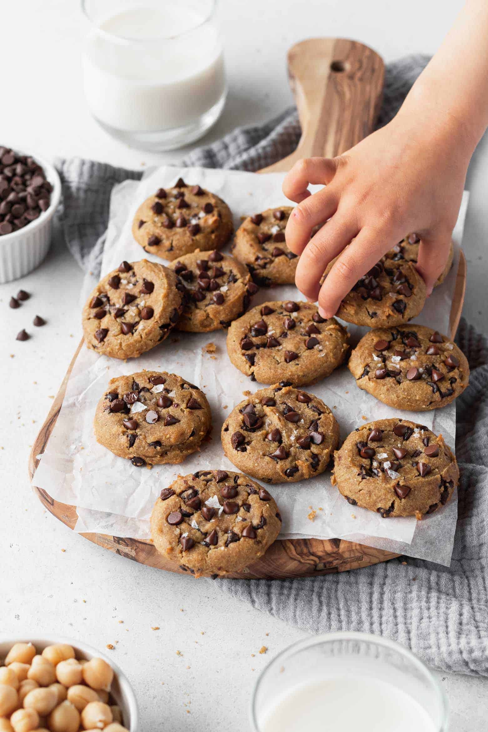 A child's hand reaching to grab a cookie