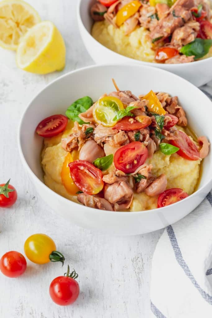 This vegan grits recipe is the perfect gluten-free meal! Creamy vegan polenta cooked in coconut milk is topped with savory jackfruit confit with tomatoes and basil!