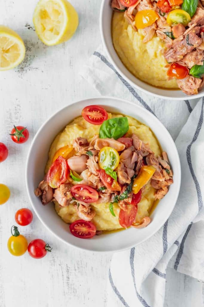 This vegan grits recipe is the perfect gluten-free meal! Creamy vegan polenta cooked in coconut milk is topped with savory jackfruit confit with tomatoes and basil!