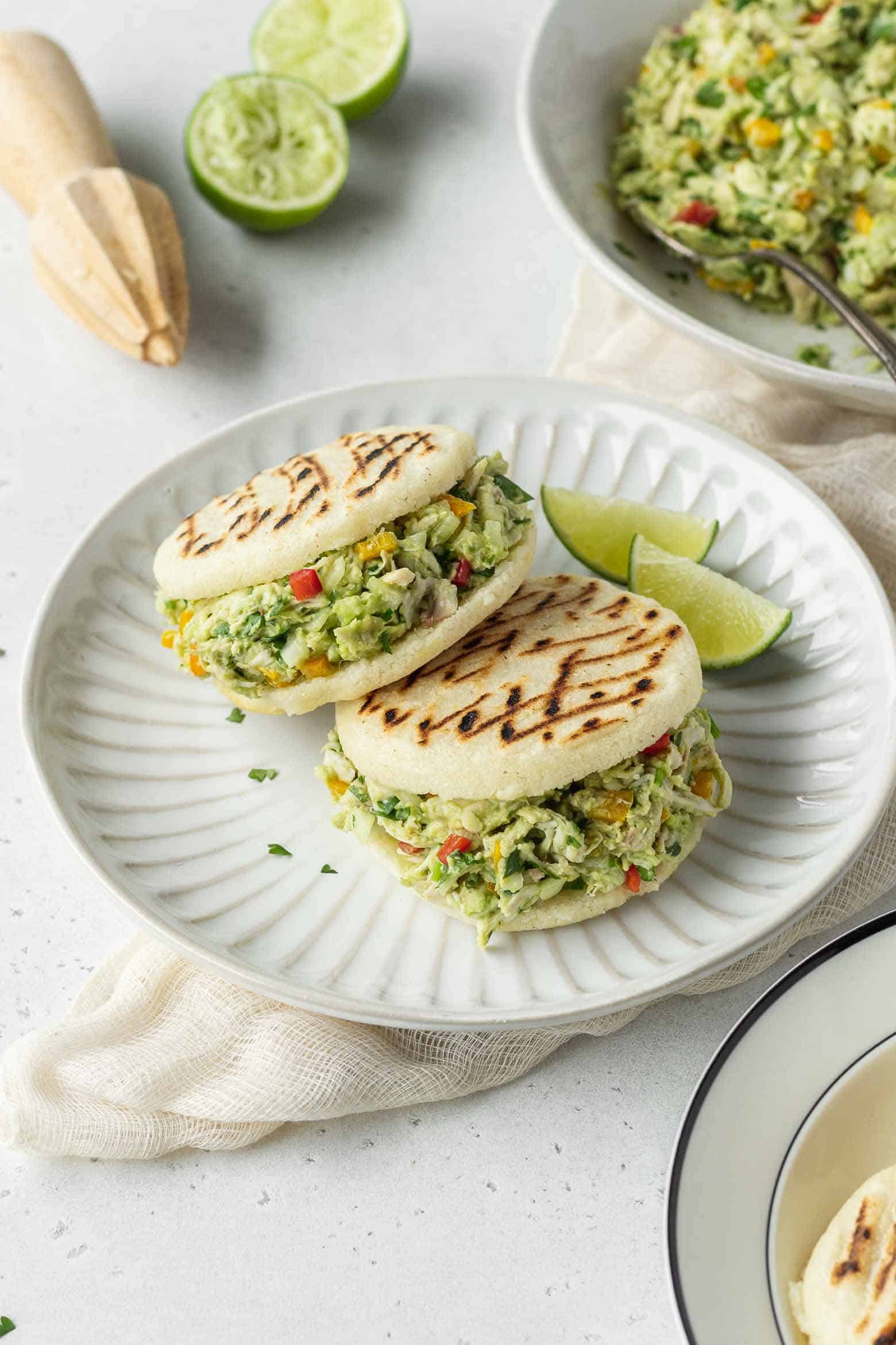 Two reina pepiada arepas on a plate