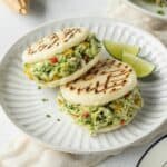 Two reina pepiada arepas on a plate