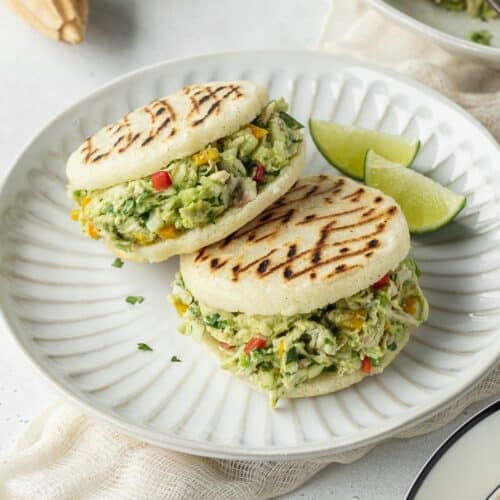 Two reina pepiada arepas on a plate