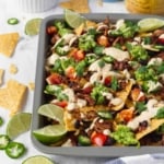 Vegan nachos with jackfruit and vegan queso is amazing! Tortilla chips, jackfruit, black beans, tomatoes, guacamole, jalapeños, cilantro, and creamy queso! #vegannachos #vegancheese #veganqueso #jackfruit #veganmexicanfood