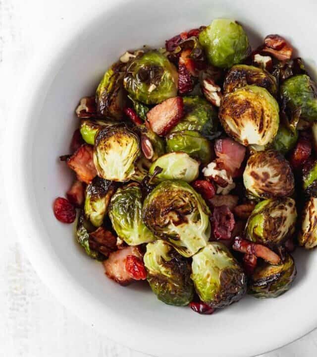 Brussels sprouts that don't suck and are actually delicious! Brussels sprouts are roasted with bacon, dried cranberries, and pecans. #roastedbrusselssprouts #brusselssprouts #thanksgivingsidedish #thanksgivingdinner #sprouts
