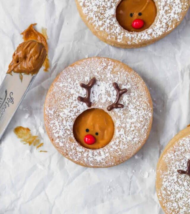 Creamy Biscoff spread is sandwiched between two buttery cookies and decorated to look like Rudolph! Cute and minimalist Christmas cookies! #rudolph #rudolphcookies #christmascookies #cookieexchange