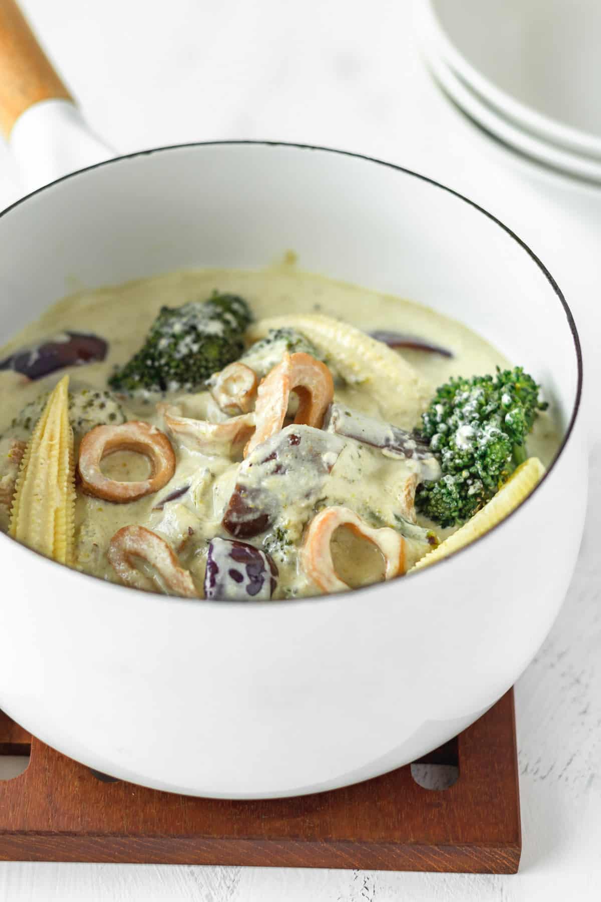 A white saucepan of Thai green curry.