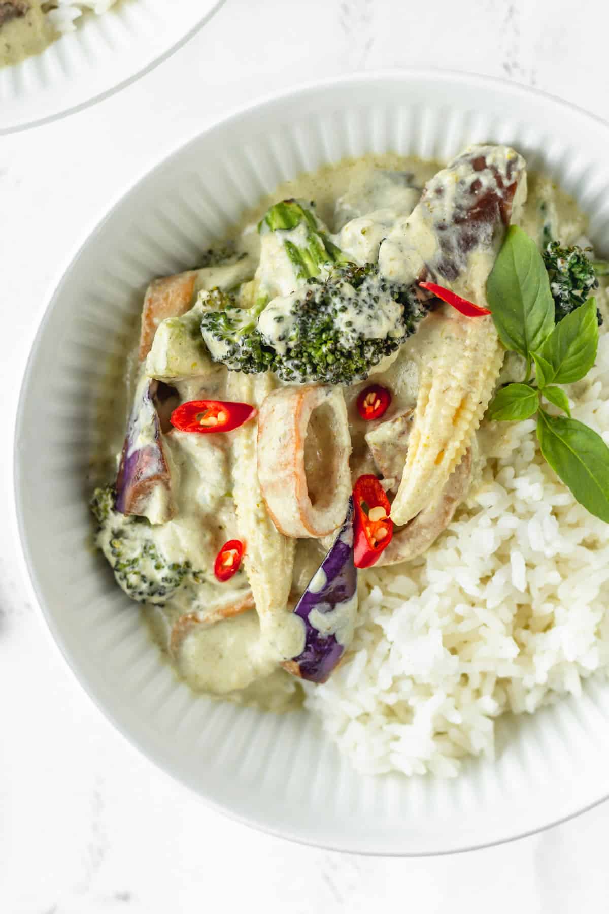 Overhead shot of a white bowl of vegan Thai curry with white rice.