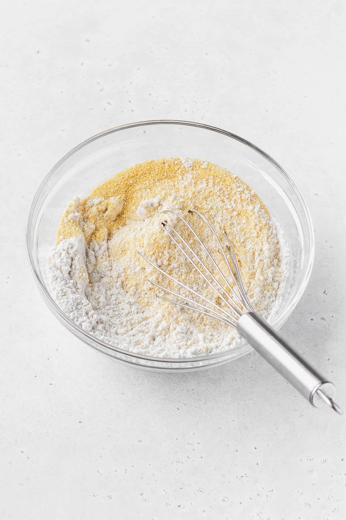 Dry ingredients for dairy-free cornbread being whisked together.