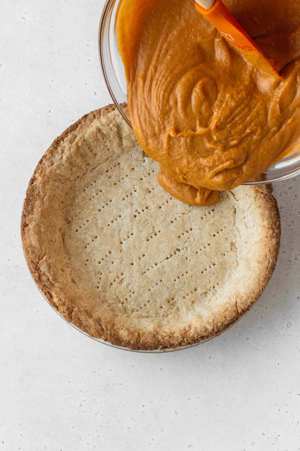 Dairy free pumpkin pie filling poured into the baked pie crust.