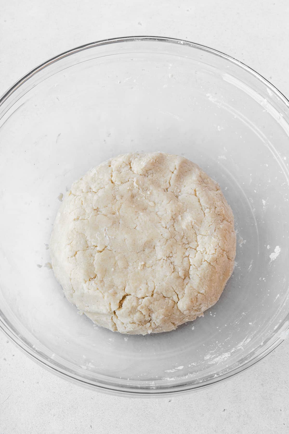 Dairy free pie crust shaped into a round disk in a glass bowl.