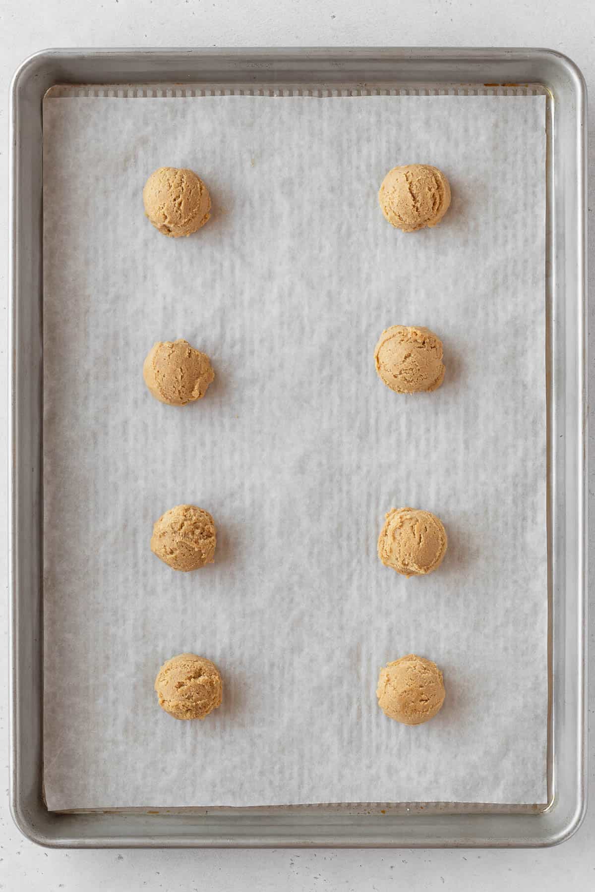 Gluten free ginger cookie dough scooped on a baking sheet.