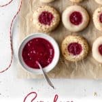 Long vertical pin of vegan thumbprint cookies laid on a brown parchment paper.