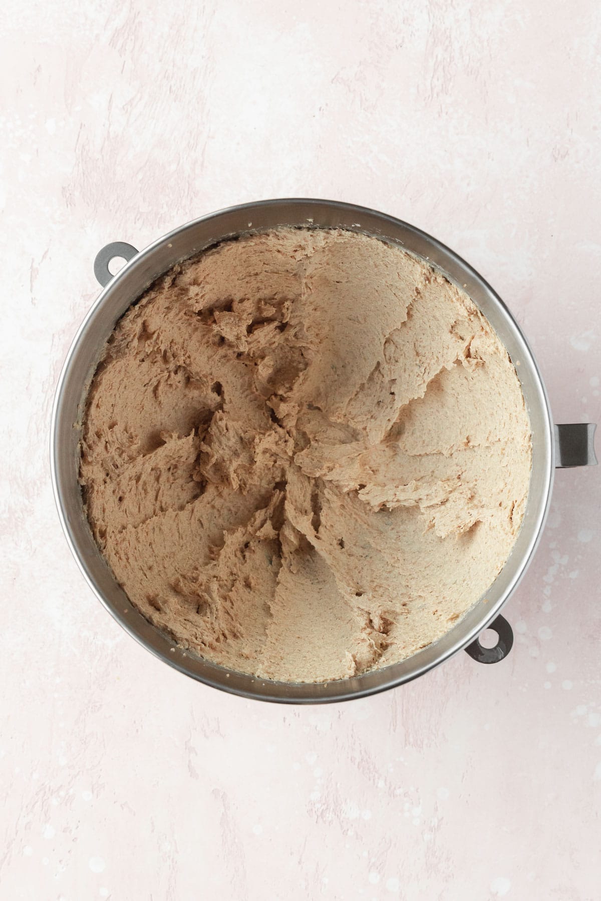 Butter, coconut oil, and sugar that has been creamed in a silver bowl.