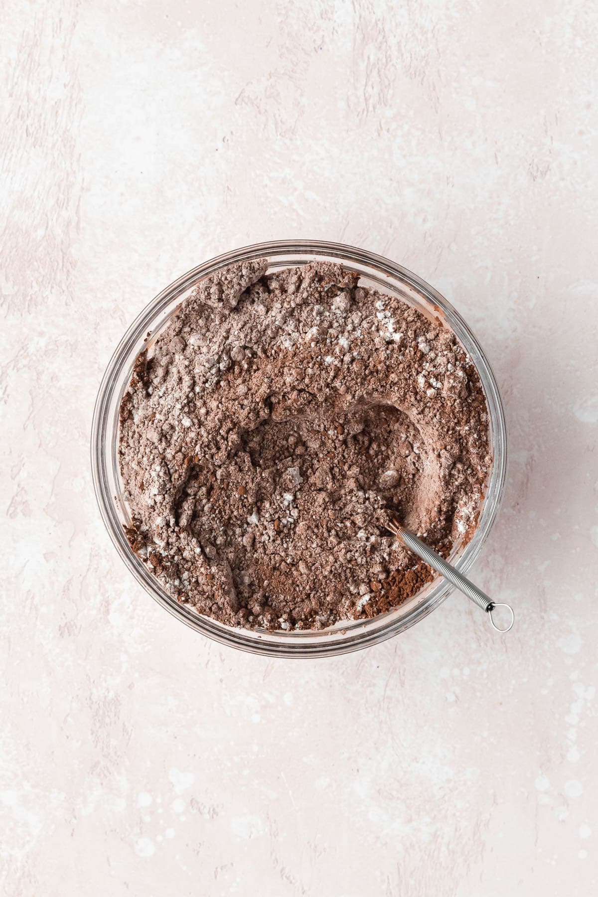 Flour, cocoa powder, salt, baking soda, and baking powder mixed together in a glass bowl.