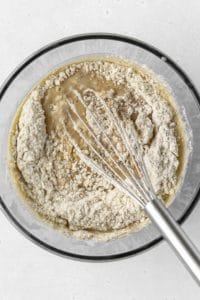 Dry ingredients being whisked into wet ingredients.