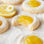 A bitten lemon curd cookie on a piece of parchment paper.