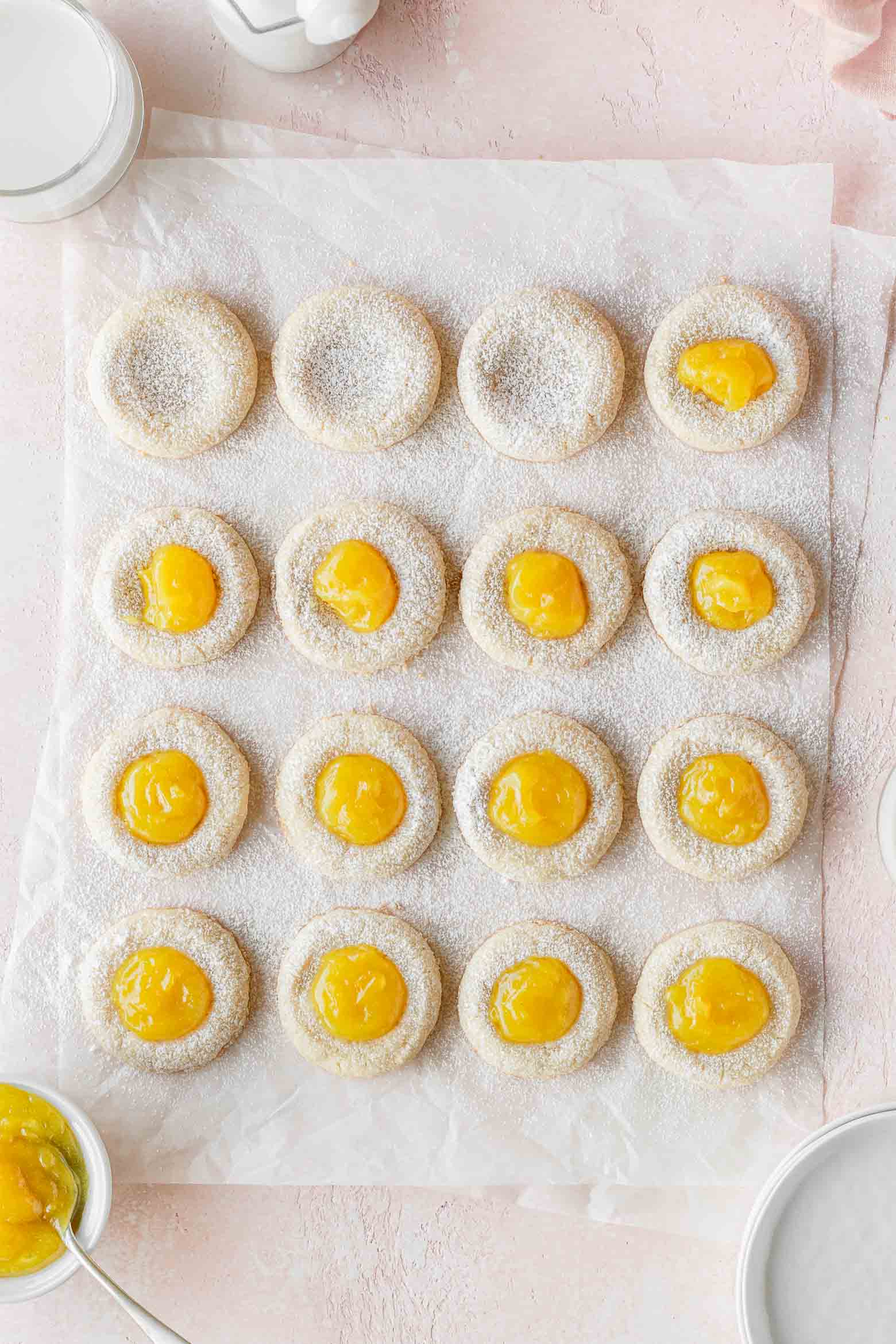 Lemon thumbprint cookies being filled with lemon curd.