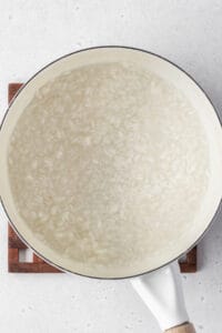 A pot with rice cooking in water.