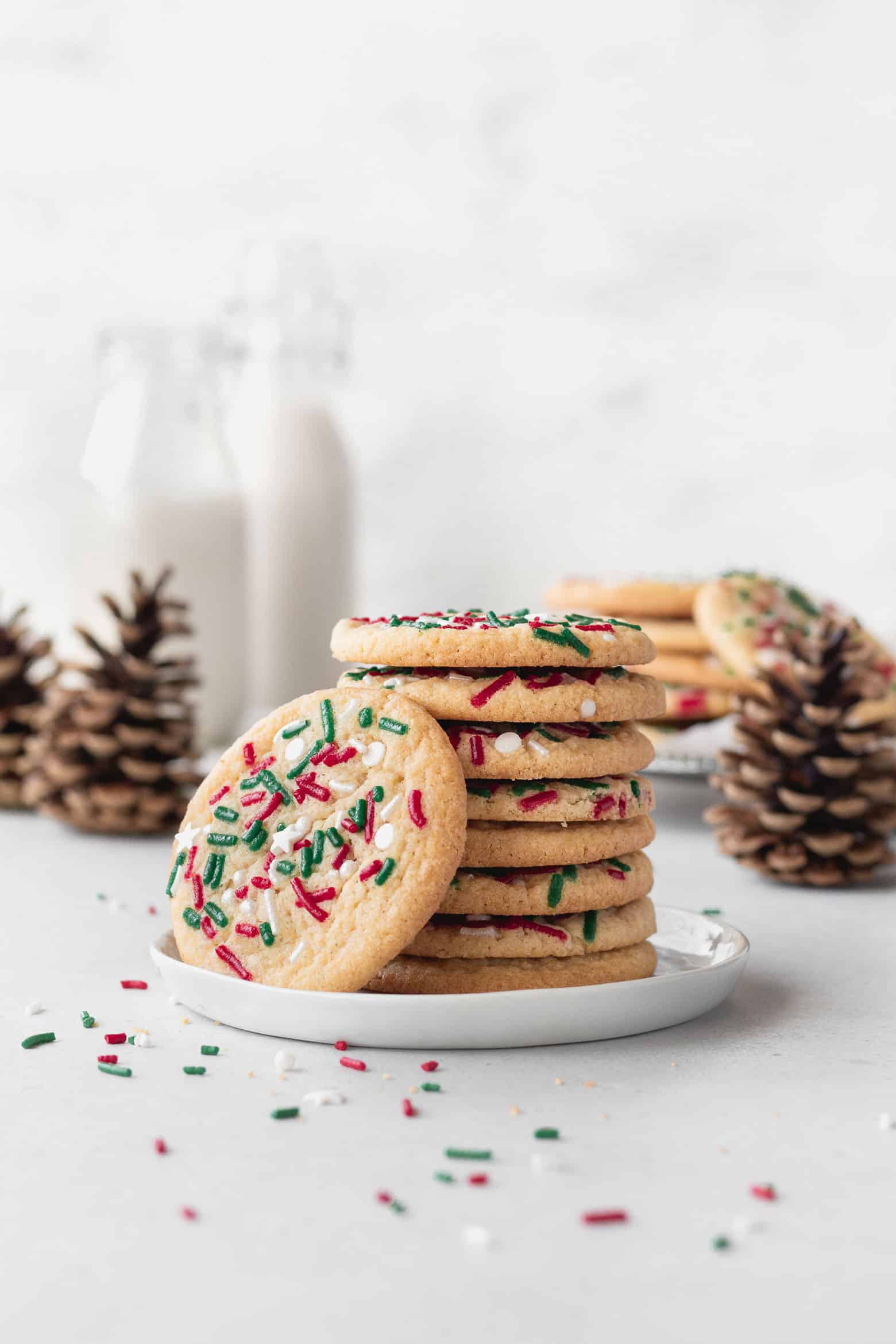 A stack of gluten free Christmas cookies on a white dessert plate.