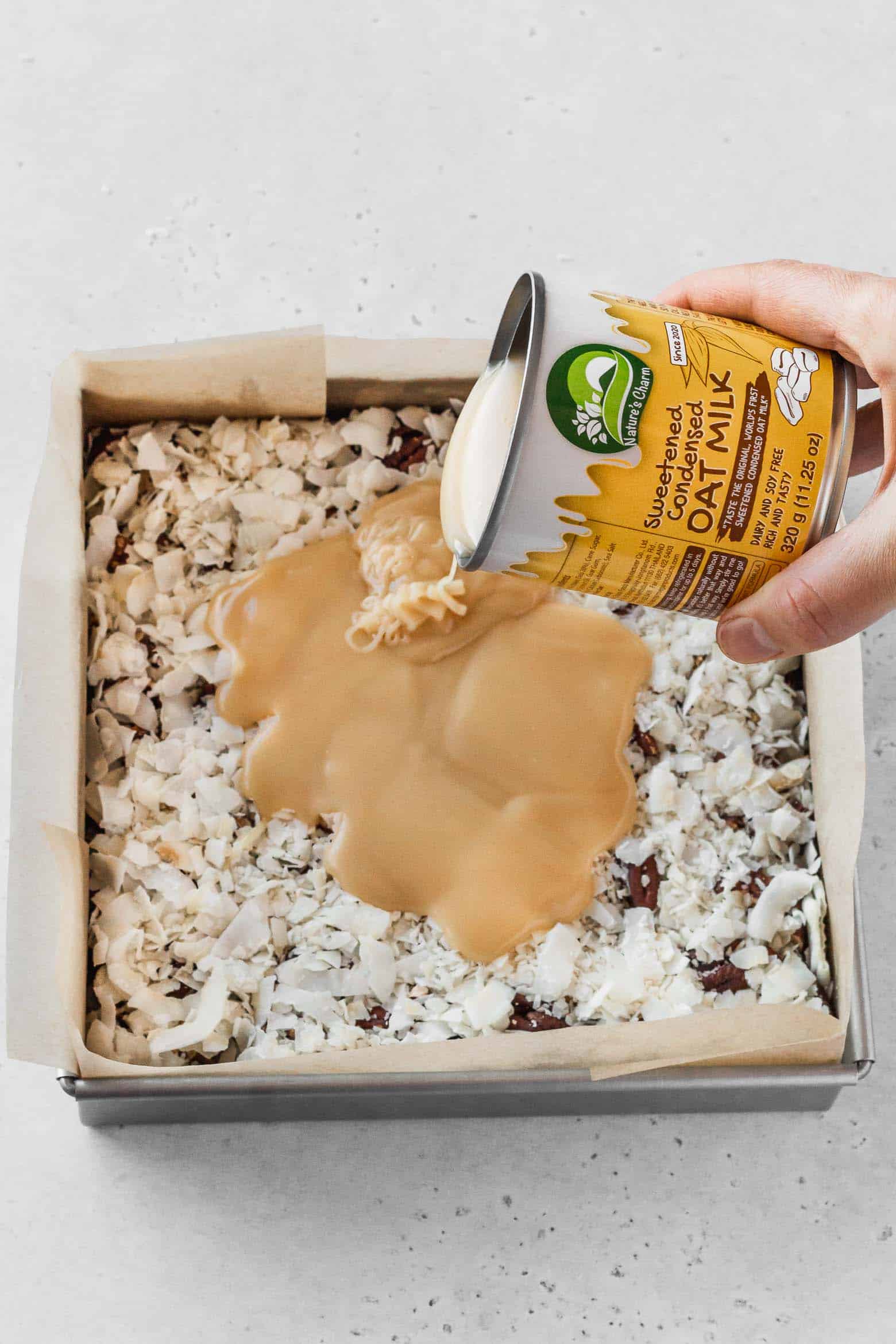 Pour a can of vegan sweetened condensed milk over the coconut.