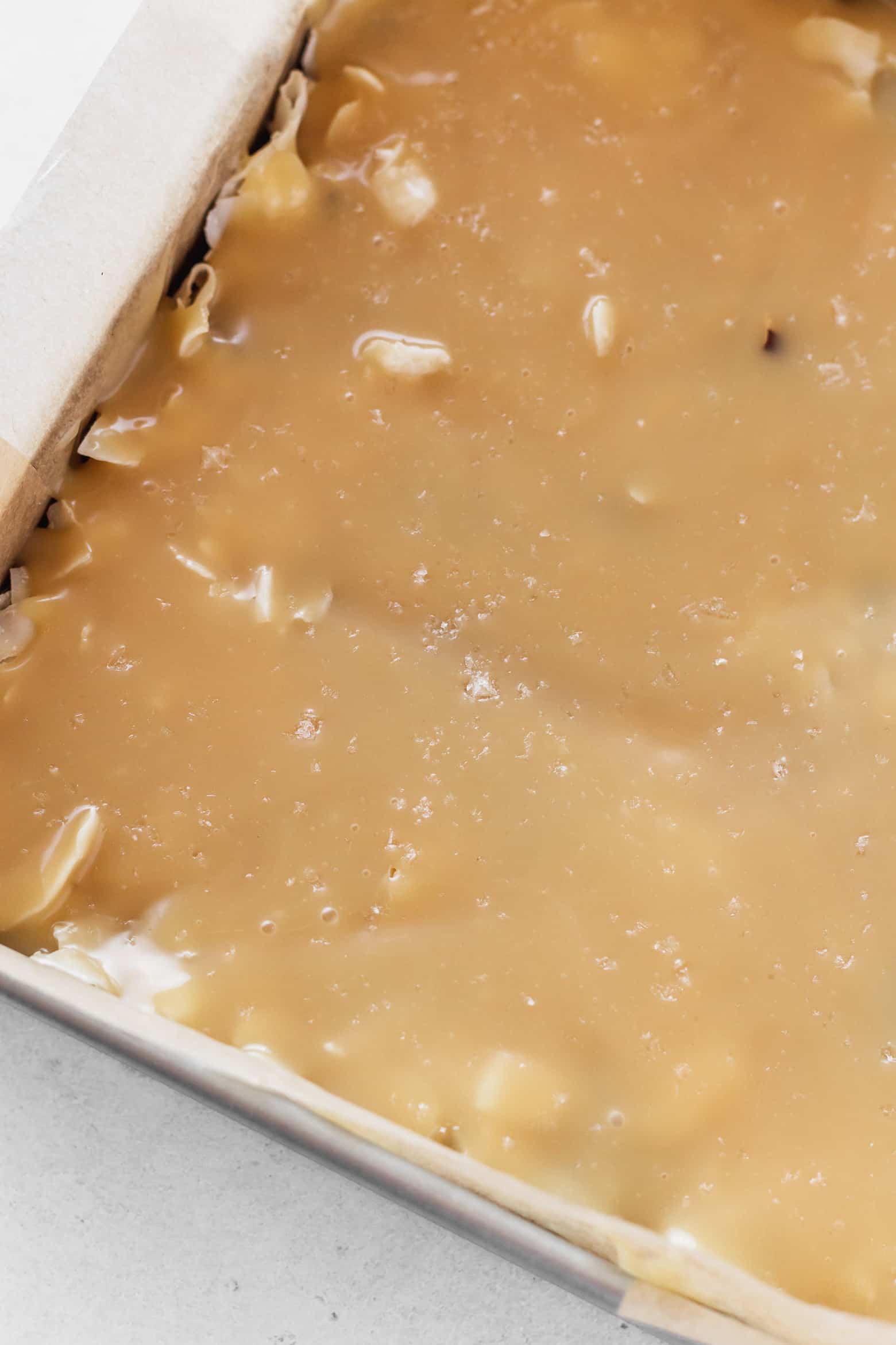 Flaky salt sprinkled over vegan sweetened condensed milk.